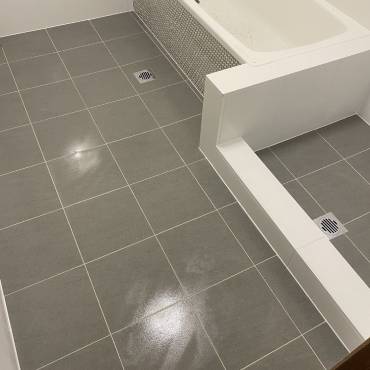 Gaffneys work in progress: grey floor tiles meeting a white tiled bath hob