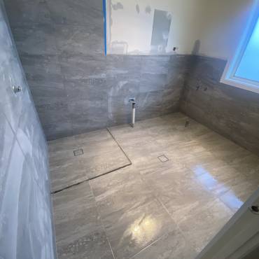 Gaffneys work in progress: a tiled floor and part-tiled walls before fixtures are installed