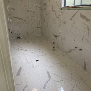 Gaffneys work in progress: marble-look tiles on walls and floor before fixtures are installed