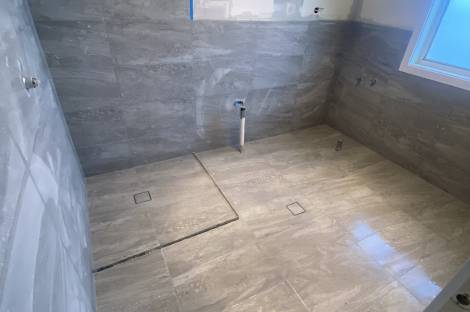 Gaffneys work in progress: grey floor tiles laid and walls part tiled, before fixtures